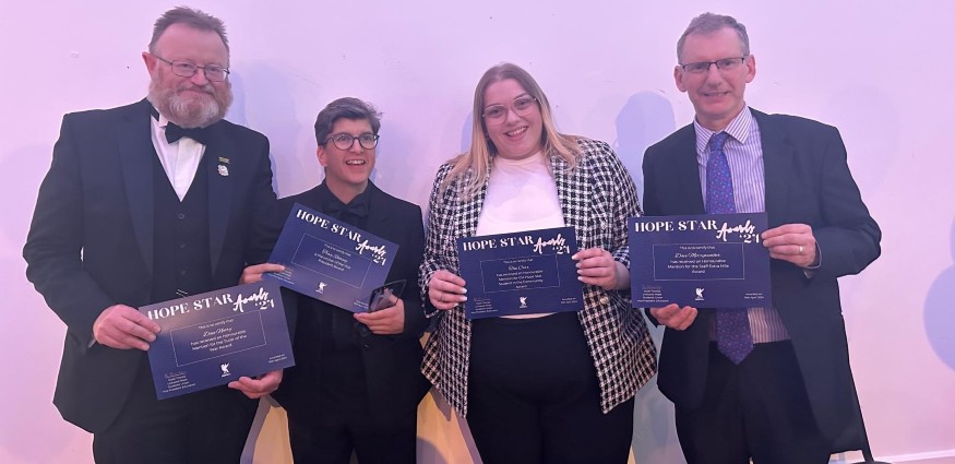 Two males and two females holding certificates.